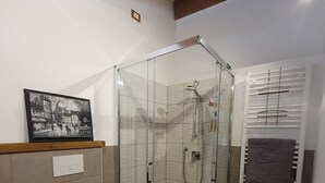 A modern bathroom with a glass-enclosed shower, a toilet, and a towel rack. - The pigsty in the valley of Assisi (Assisi)