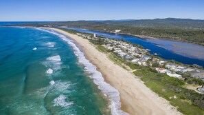 A coastal area with a beach, a river, and a residential area with houses. - Birdsong - Central location (Wooli)