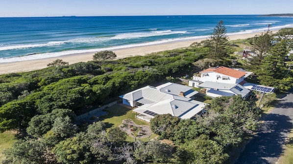 A coastal property with a large house, solar panels, and a view of the ocean. - Birdsong - Central location (Wooli)