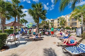 Relax by the pool surrounded by palm trees and enjoy the resort's tranquil atmosphere.