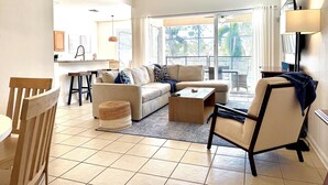 A spacious living room with a sofa, armchairs, a coffee table, and a dining area with a table and chairs. - Disney | Pool&Spa | Windsor Hills | Privacy | Amazing Views (Kissimmee)