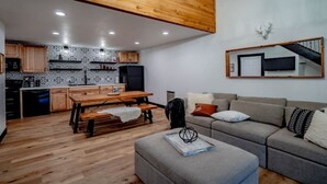Une cuisine moderne avec des meubles en bois, une table à manger et un canapé dans l’espace salon.