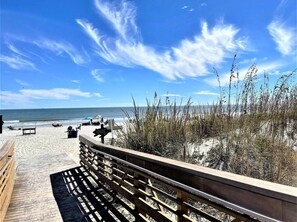 Walk along the boardwalk to the ocean's edge, where the sandy shoreline meets the sea.