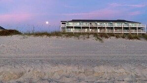 A beachfront hotel with a two-story structure, multiple balconies, and a sandy beach in the foreground. - Amazing Ocean Views From Your Newly Renovated Oceanfront Condo in Carolina Beach (Carolina Beach)