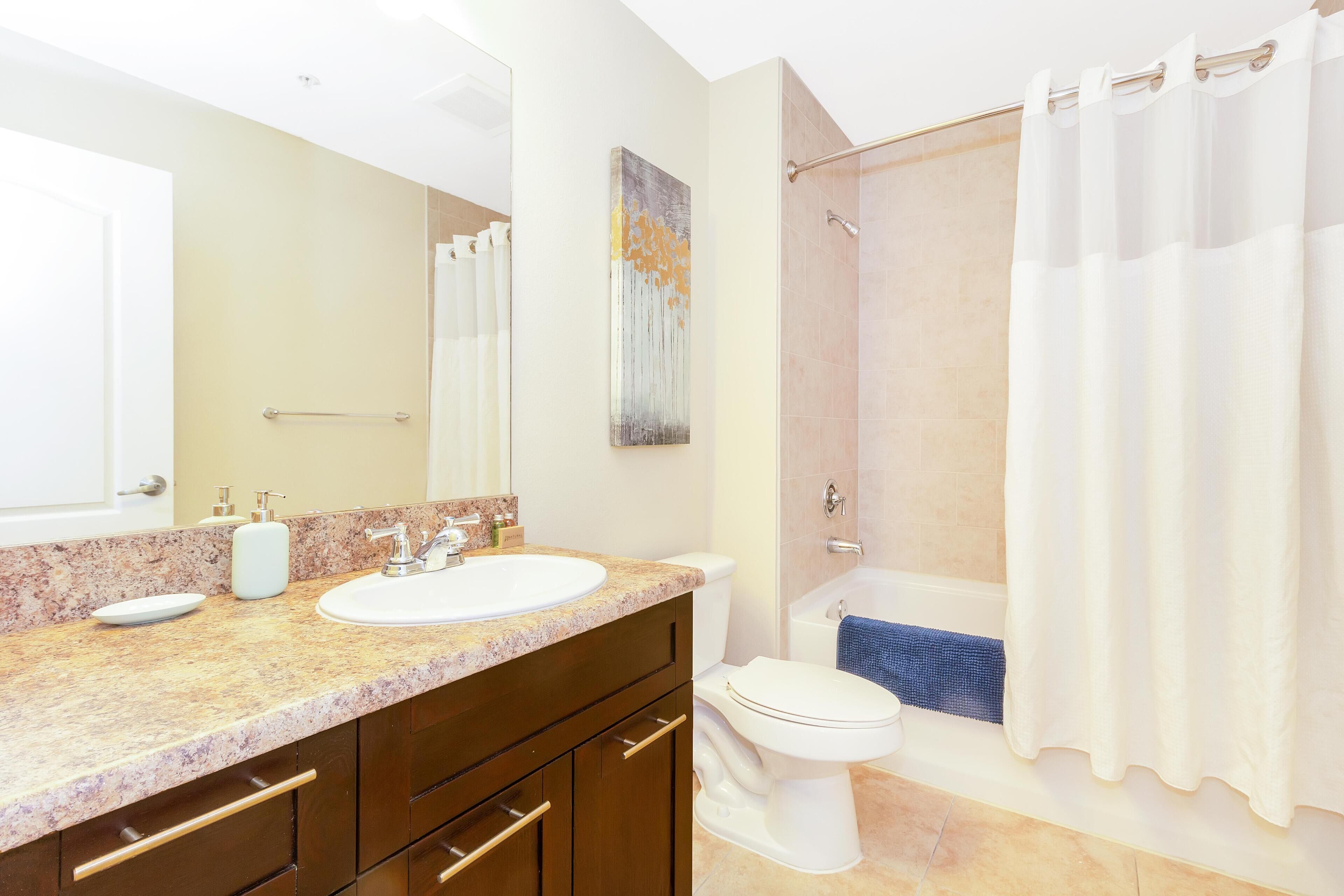 A bathroom with a sink, toilet, and shower.