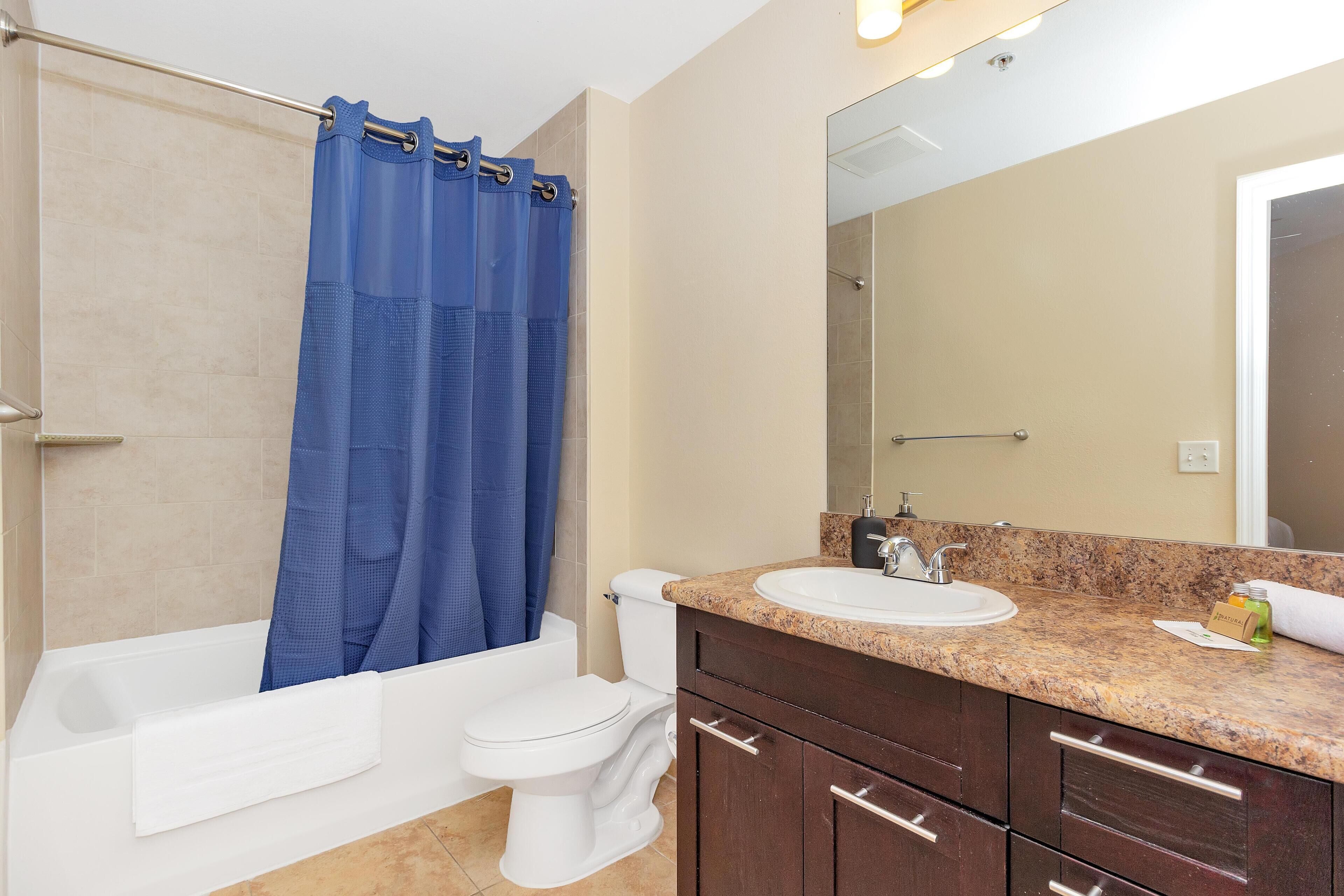 A bathroom with a bathtub, toilet, and sink.