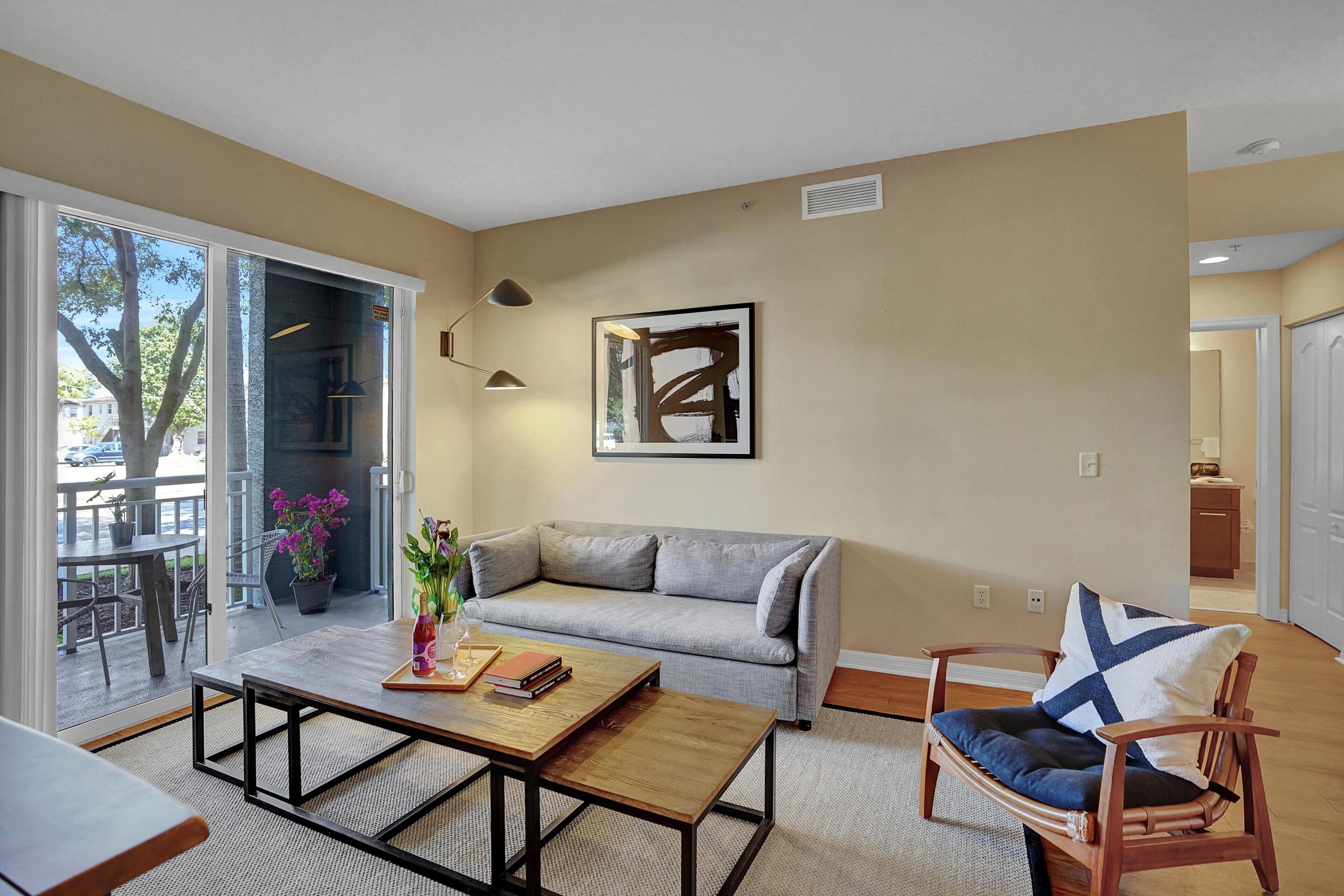 A modern living room with a grey sofa, wooden coffee table, and a wicker chair.