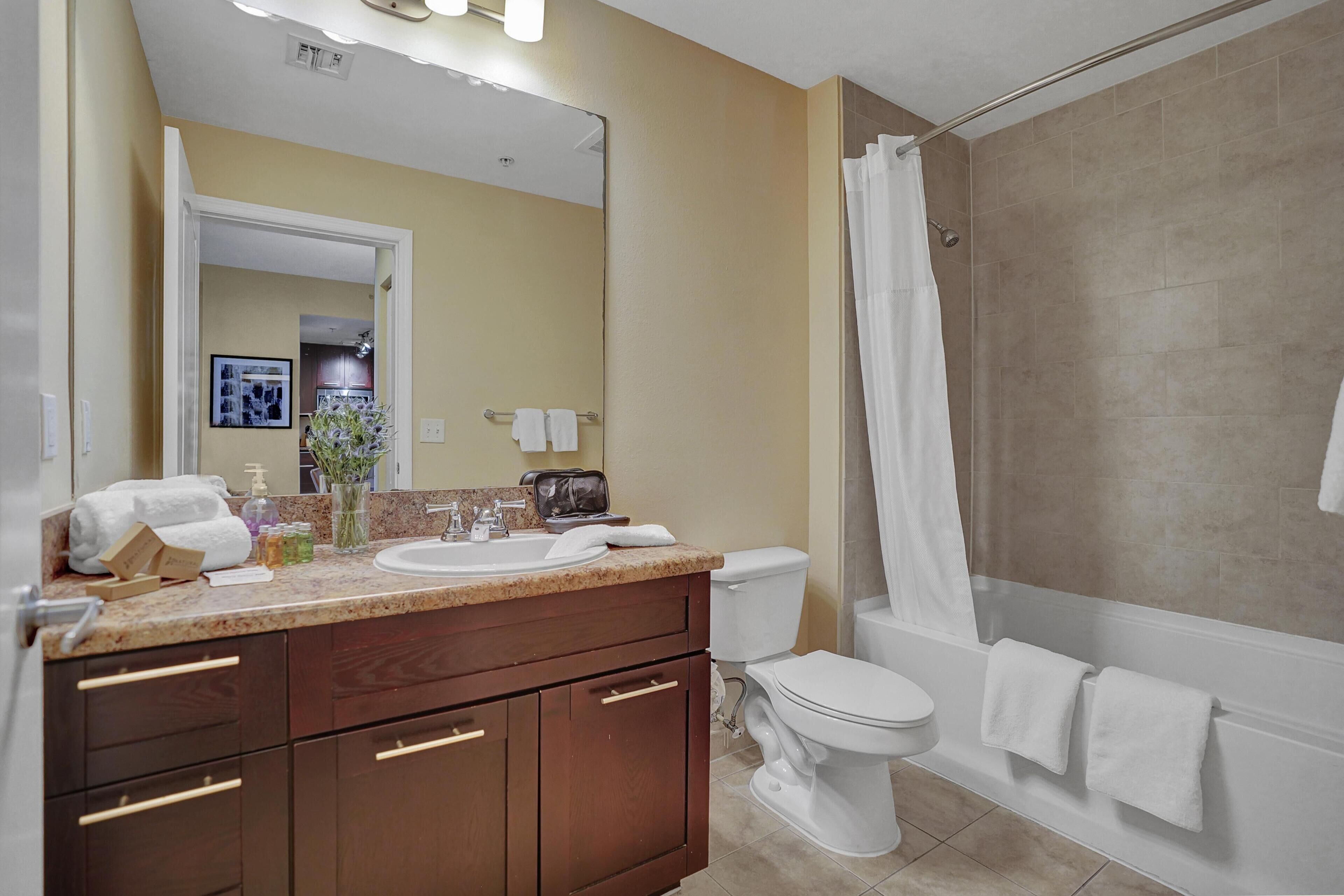 A modern bathroom with a sink, toilet, and shower.