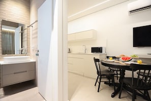 Un baño moderno con un espejo grande, un lavabo y una zona de ducha.