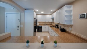 A modern kitchen with white cabinets, a granite countertop, and a built-in oven. - Lake view spacious 2bdr CONDO 7 min by the BEACH (Sarasota)