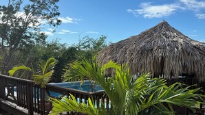 A thatched-roof structure with a pool and a wooden deck. - Private 2 bedroom Casitas with pool. Azteca villas (Treasure Beach)