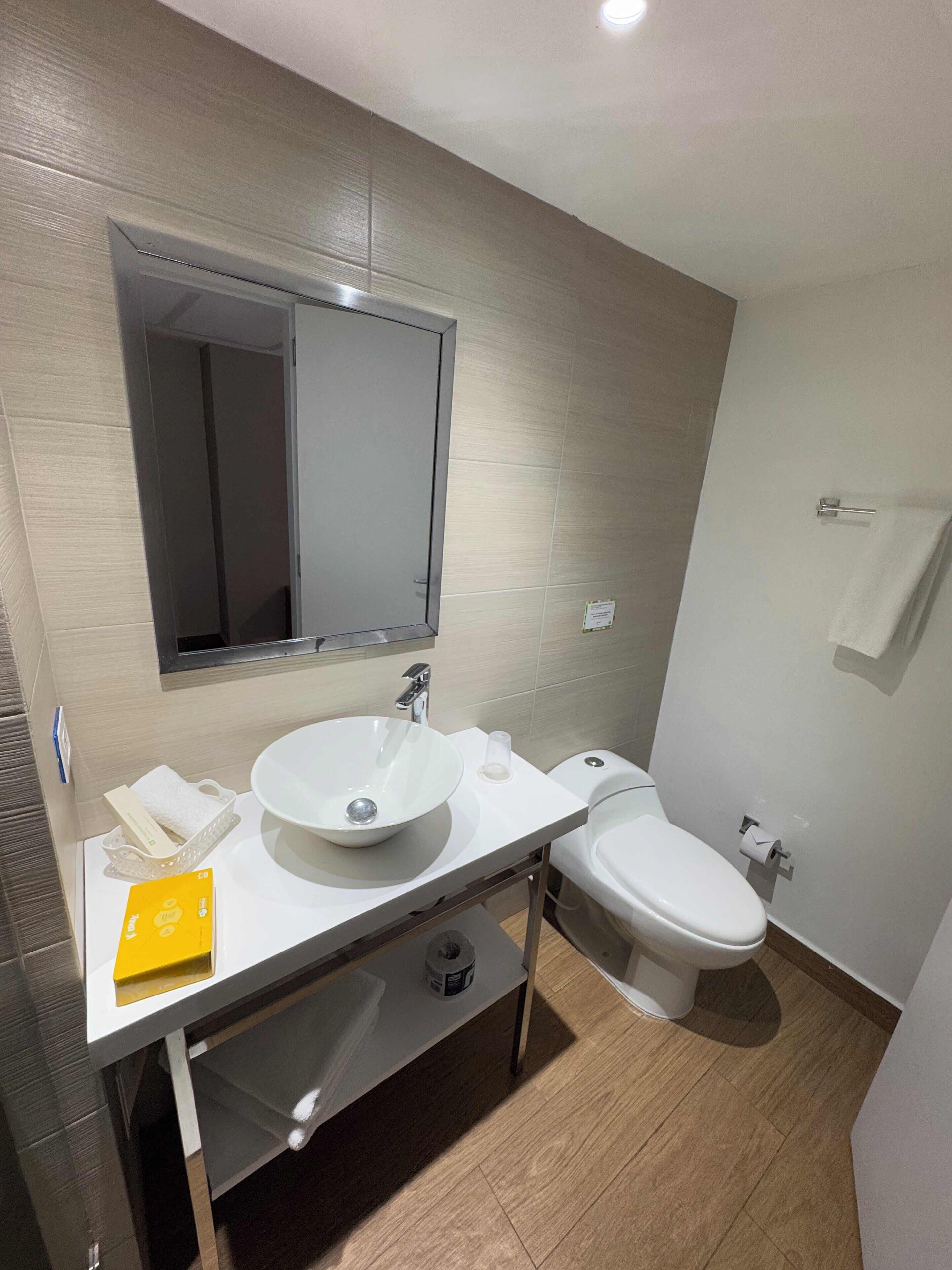 Un baño moderno con dos lavamanos, un inodoro y un espejo.