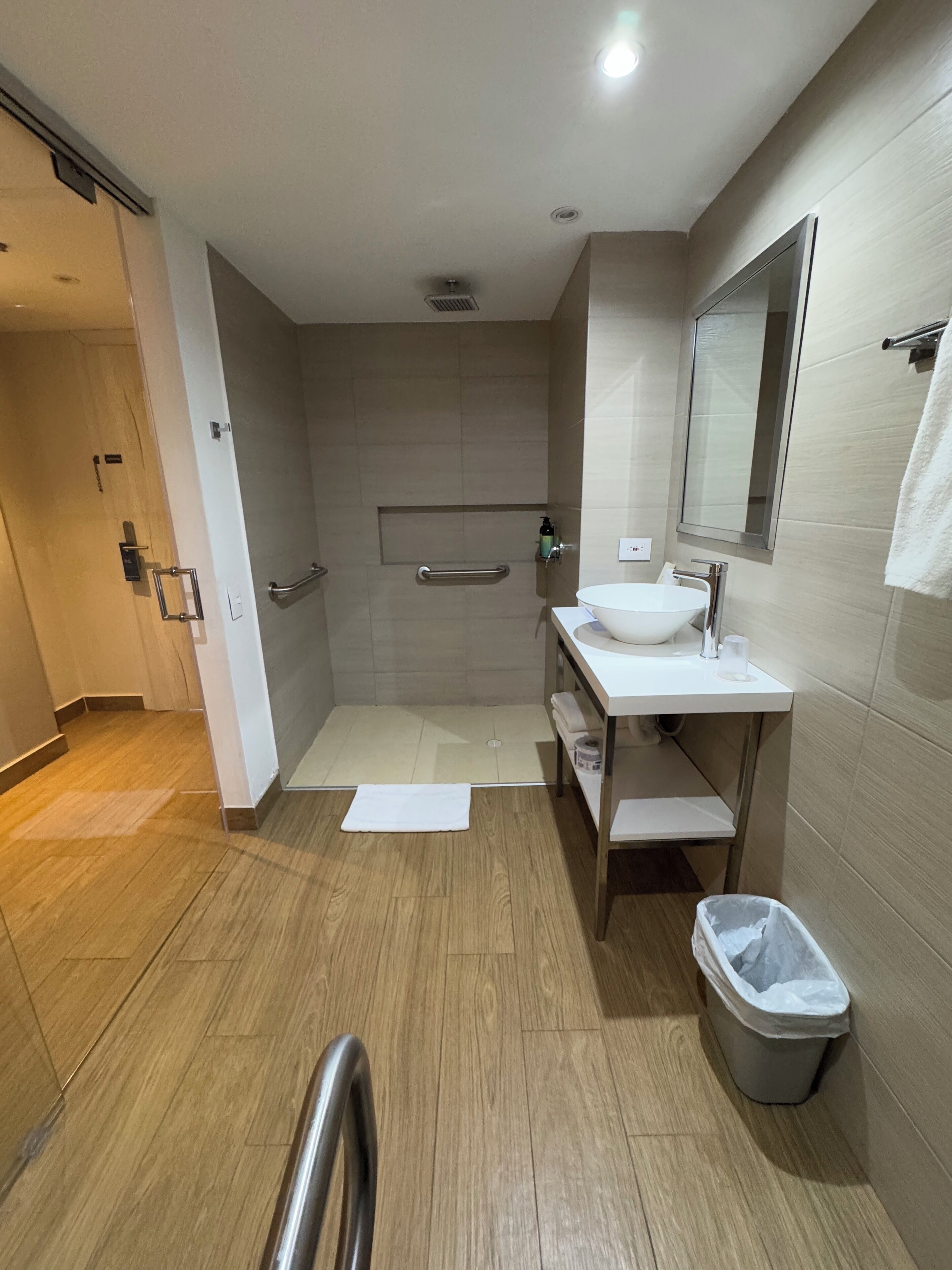 A modern bathroom with a shower, sink, and toilet.