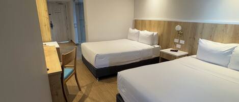 Una habitación de hotel con dos camas, un escritorio y una silla.