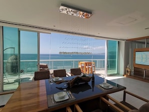 Enjoy meals with a view of the ocean from this spacious dining area with a large table for four.