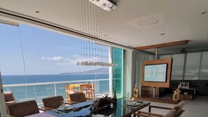 A modern dining area with a large table and comfortable seating, overlooking a scenic ocean view. - BEACHFRONT PENTHOUSE with PRIVATE POOL (Nuevo Vallarta)