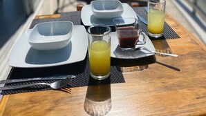 A table set with plates, cutlery, and drinks on a balcony with a view of the ocean. - BEACHFRONT PENTHOUSE with PRIVATE POOL (Nuevo Vallarta)