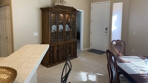 A dining area with a wooden cabinet, a dining table, and chairs. - Rancho Vistoso Getaway (Oro Valley)