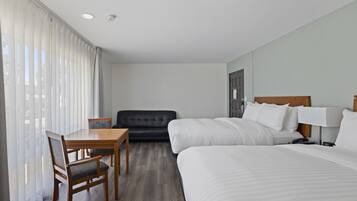A hotel room with a bed, a desk, and a couch.