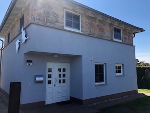 A two-story house with a white exterior, a front door, and two windows on the upper floor. - Am Bahndamm 73 "Haus Meerblick" - bright and friendly vacation home in (Zingst)