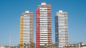 Tres edificios altos con un cielo azul despejado al fondo.