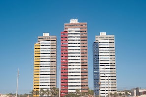 Três edifícios altos com um céu azul límpido ao fundo.