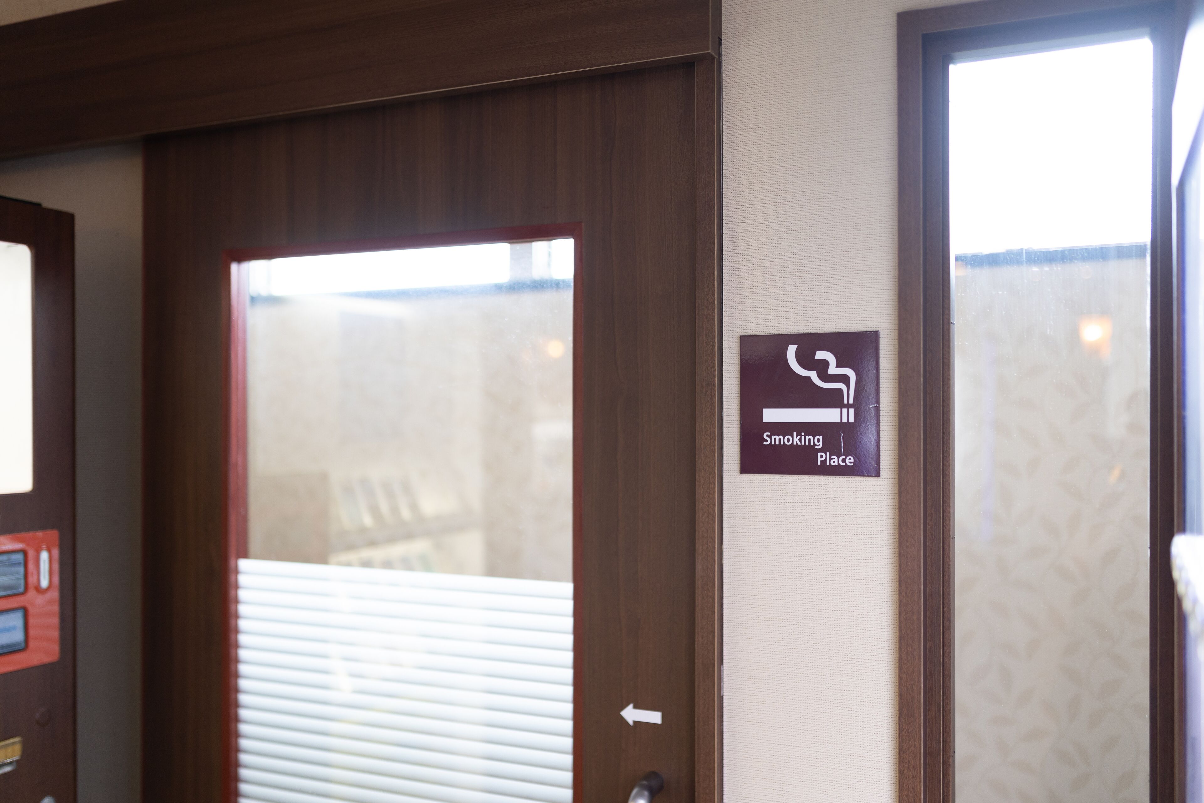 A door with a sign indicating a smoking area.
