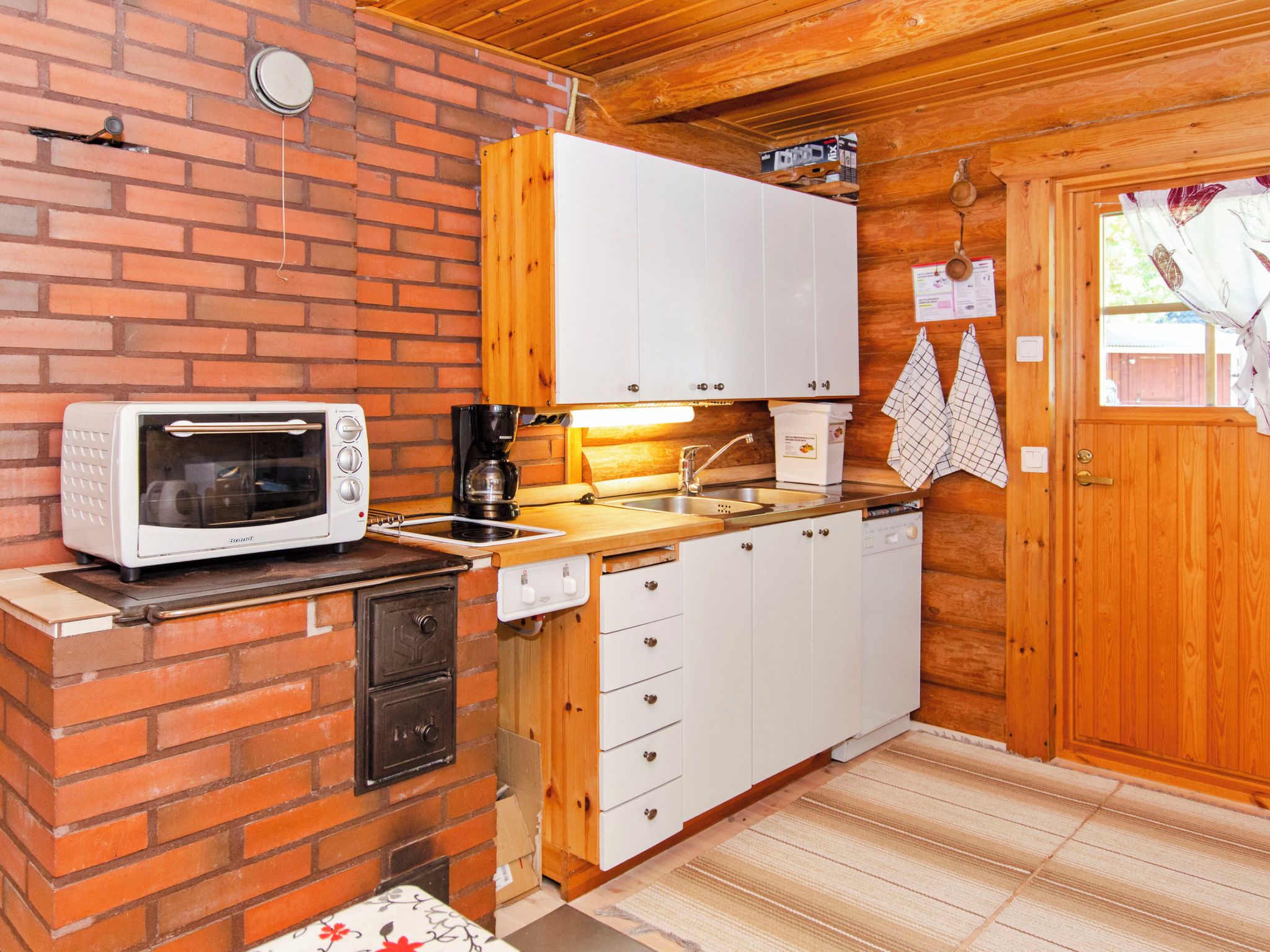 A compact kitchen with a microwave, coffee maker, and a sink.