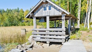 A wooden cabin with a wooden deck leading to a small dock over water. - Suvituuli by Interhome (Liperi)