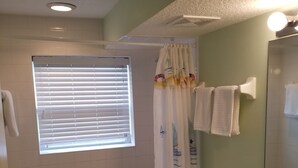 A bathroom with a bathtub, toilet, and sink. - Beach-living 2 bed (Fernandina Beach)
