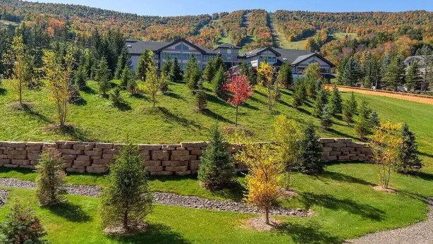A large, modern building with multiple sections, surrounded by a well-maintained lawn and trees. - Luxury Windham Mtn Slope Side 3 BDRM Condo (Windham)