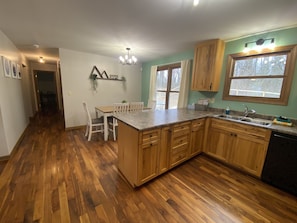 A kitchen with wooden cabinets, a granite countertop, and a dishwasher.