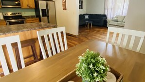 A dining area with a wooden table, chairs, and a tray with a plant.