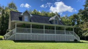 A two-story house with a covered porch and a small front yard.