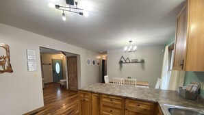 A kitchen with wooden cabinets, granite countertops, and a double sink.