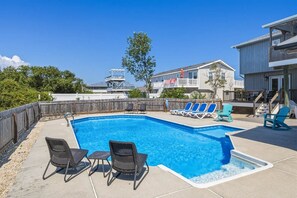 A swimming pool with lounge chairs and a wooden deck. - Sandpiper Paradise | 630 ft to the beach | Private Pool (Virginia Beach)