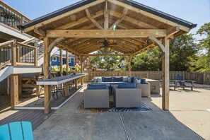 An outdoor patio with a wooden pergola, seating area, and a table. - Sandpiper Paradise | 630 ft to the beach | Private Pool (Virginia Beach)