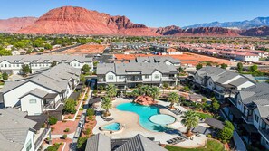 A residential area with houses, a swimming pool, and a mountain in the background.
