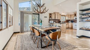 A spacious kitchen with a large island, wooden cabinets, and a chandelier. - Cozy Mountain Escape | Hot Tub +Views | Dog Friendly | Sleeps 10 | 45 min Denver (Evergreen)