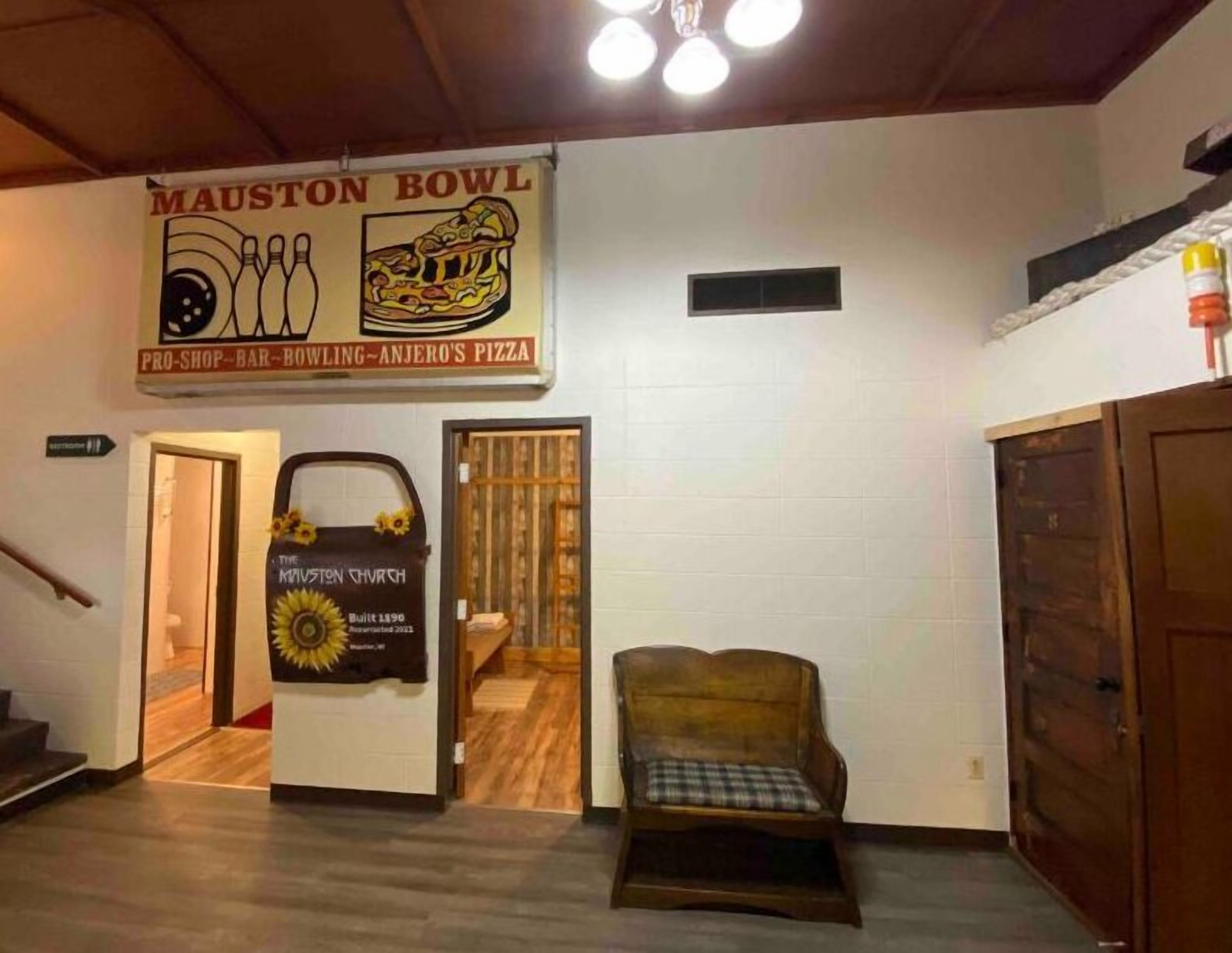 A bowling alley with a sign for 'Mauston Bowl' and 'Anjero's Pizza'.
