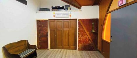 Una habitación con un banco de madera, un letrero sobre una puerta y una señal de salida.