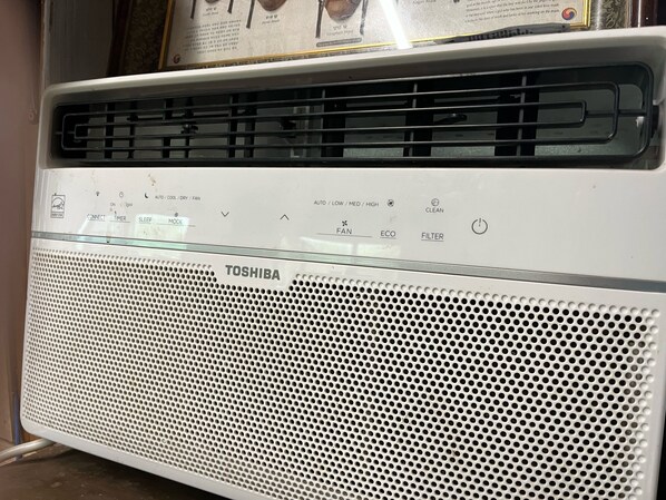 Eine weiße Toshiba Klimaanlage mit Bedienfeld und einem gelochten Frontgitter.