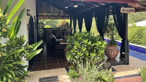 A covered outdoor seating area with a 'ducha' sign, a refrigerator, and a 'BIENVENIDO' welcome sign. - VIlla costa pura vida (agalla) (Ojochal)