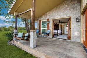 A stone building with a porch, outdoor seating, and a view of the surrounding landscape. - Luxury Ranch Retreat on 100+ Acres Near Dallas w/ Pool & Lake Access (Blue Ridge)