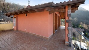 Un bâtiment doté d’un patio carrelé, d’une porte en bois et d’un pilier en pierre.