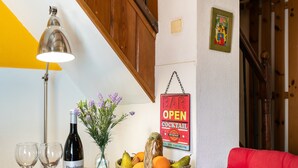 Et bord med en vinflaske, glas, en frugtkurv og et skilt, der siger 'BAR OPEN COCKTAIL'.