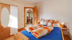 A bedroom with a bed, bedside tables, a mirror, and a wardrobe.