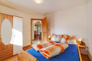 Un dormitorio con cama, mesitas de noche, un espejo y un armario.