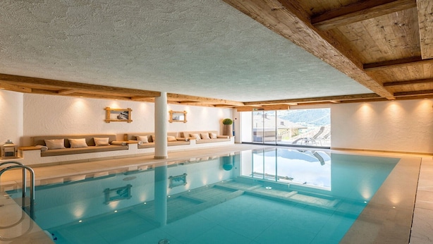 A modern indoor pool with a clear view of the mountains through large windows.