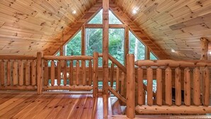 A wooden interior with a high ceiling and a large window.